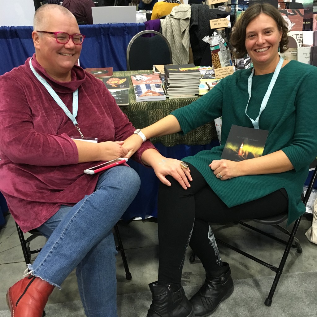 Heit (r) with her partner, the poet, performance artist, and disability activist Petra Kuppers (l), at the OS table at AWP 17.